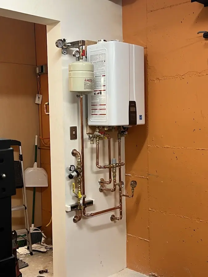 Plumbing technician inspecting water heater connections in Garrison